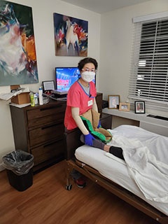 Mee Soo Kim in patients room working bedside